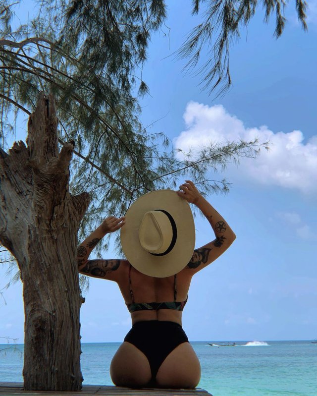 Ирина Смелая (Tatarka) в черном купальнике со шляпой на море около дерева