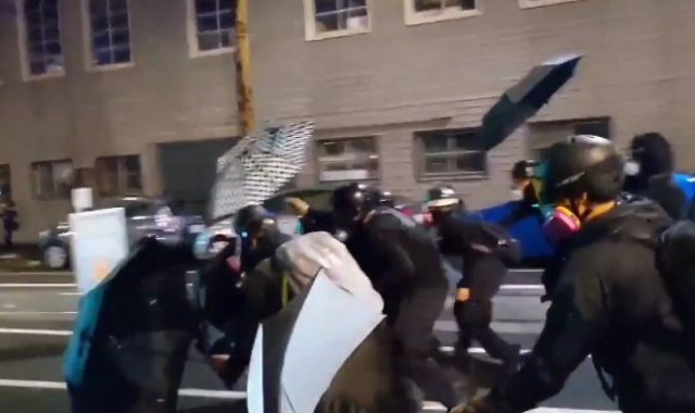 Протестующие из Портленда прикрываются зонтами от спецназа