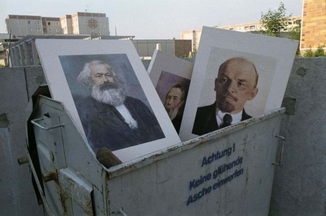 Портреты идеологов и вождей коммунизма в мусорном баке у школы в Хеллерсдорфе в Восточном Берлине. Германия. Июнь 1991 год.