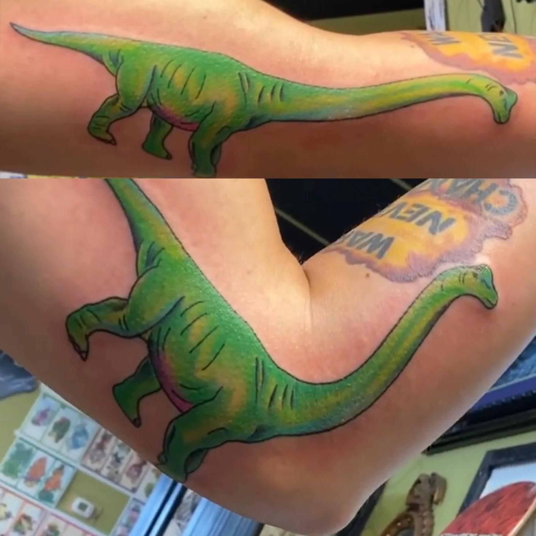 Татуировка динозавра у локтя